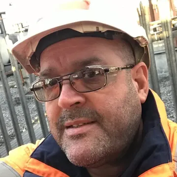 Darren Emery on site, in a hard hat and hi-vis jacket