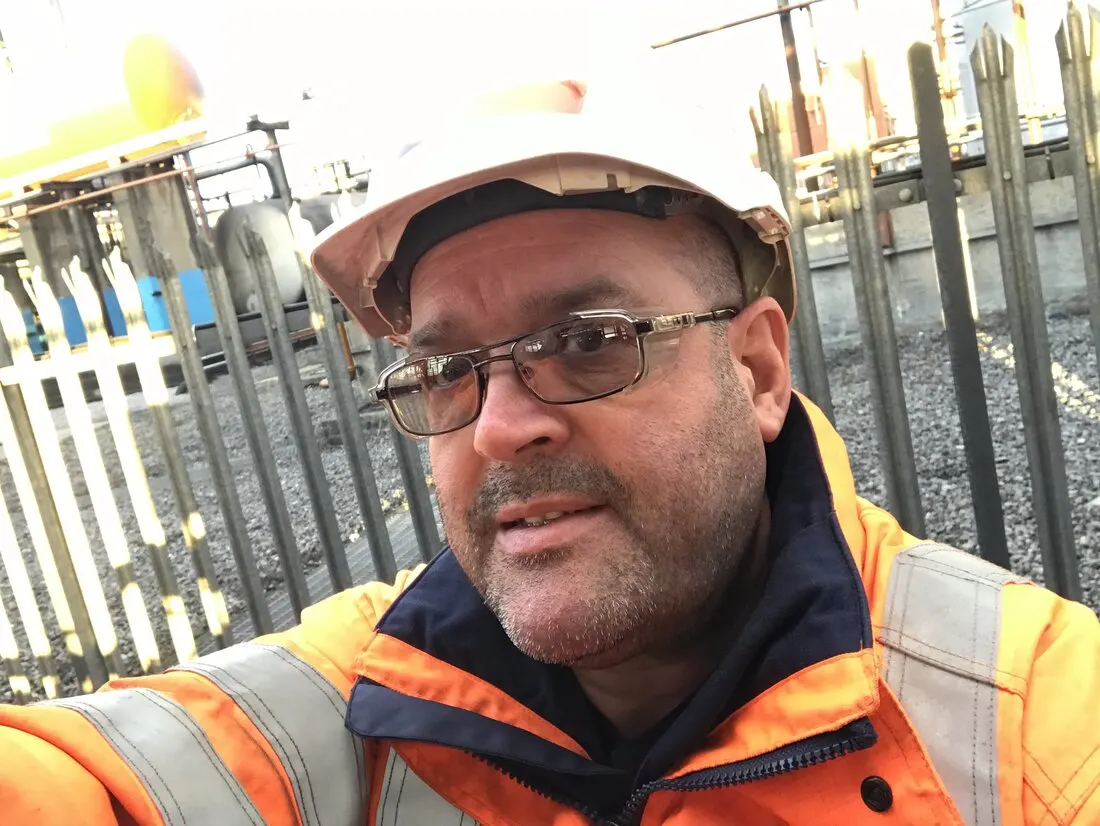 Darren Emery in a hard hat and hi-vis jacket on an industrial site